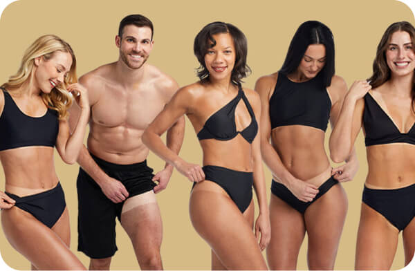 Diverse group of trainees displaying spray tan results at the Nashville class