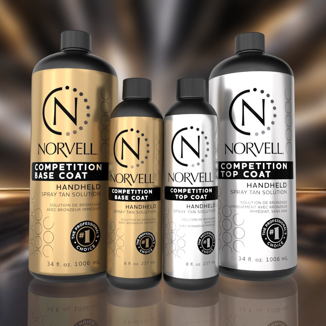 Four Norvell spray tan solution bottles on a reflective surface with a blurred background