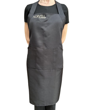 Person wearing a black apron with an embroidered Norvell logo, in front of a white background