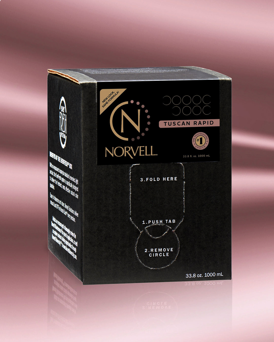 A black box of Norvell Tuscan Rapid Handheld Spray Tan Solution, featuring gold and pink accents, set against a pink gradient background with a soft reflection.
