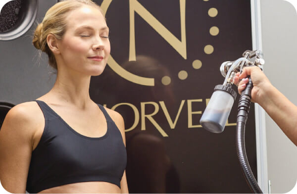 Close-up of a woman getting a professional Norvell spray tan.