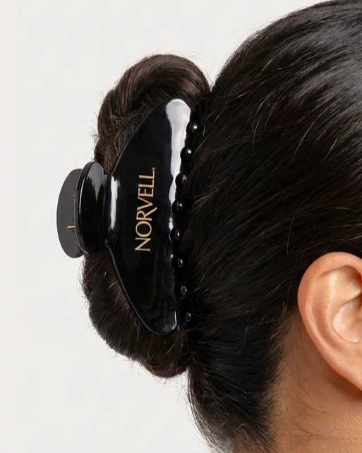 Ai Render Black hair clip with 'Norvell' branding on a bun of hair.